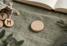 The Blank Rune Debate: History, Evidence and Modern Use Unmarked wooden token beside a pouch of marked practice runes on sage fabric.